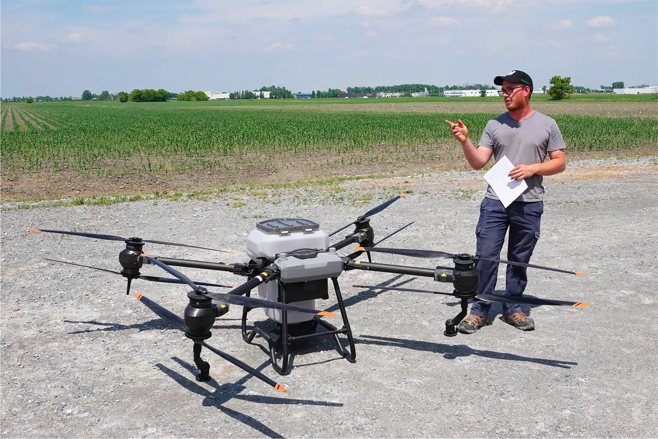 Technicien agricole des Fermes Overbeek avec un drone d’épandage devant un champ – page Nous Joindre